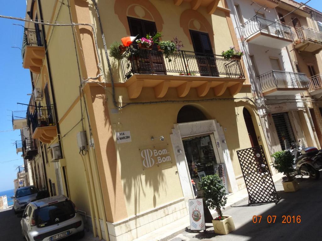 a yellow building with a door and a balcony at Monolocale La Chicca in Castellammare del Golfo