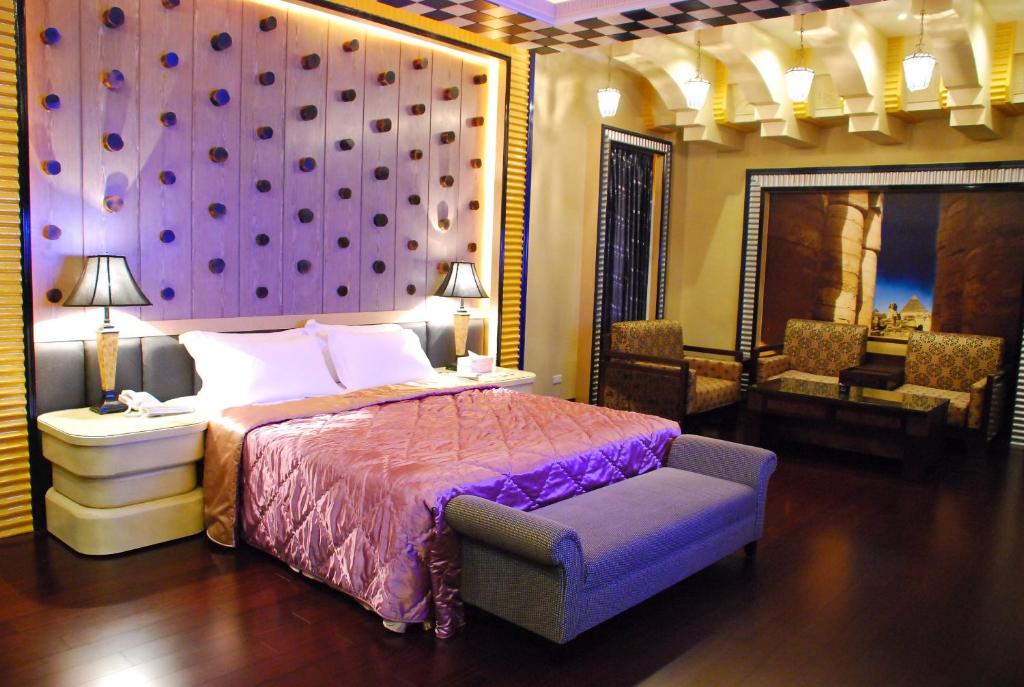1 dormitorio con cama y pared púrpura en Wei Feng Exquisite Motel Pintung Branch, en Pingtung City