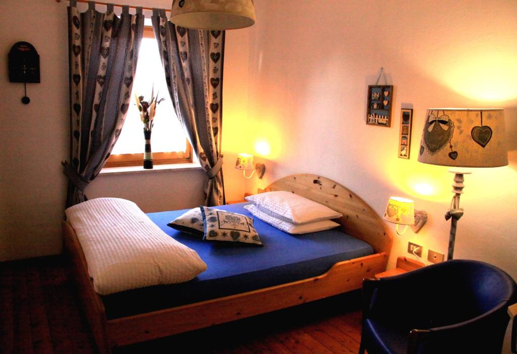 a bedroom with a wooden bed with a window at Garni Biancaneve Ruffrè-Mendola in Mendola