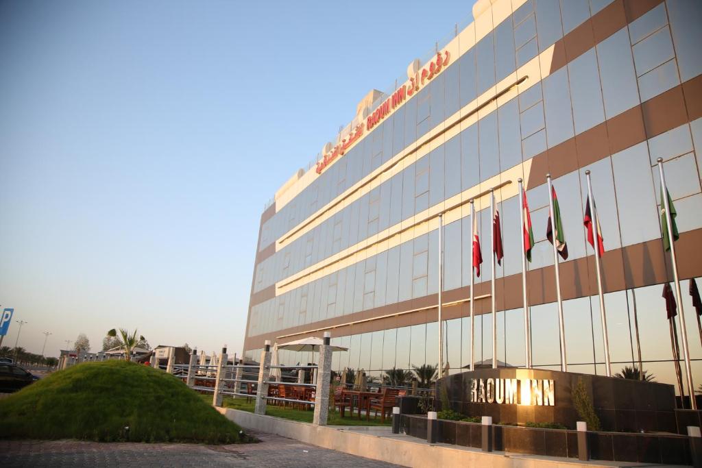 un edificio con banderas delante en Raoum Inn Khafji Corniche, en Al Khafji