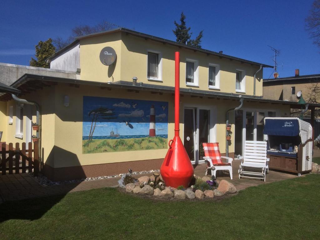 ein Haus mit einem großen roten Kegel im Hof in der Unterkunft Apartment Zum Anker in Ahlbeck