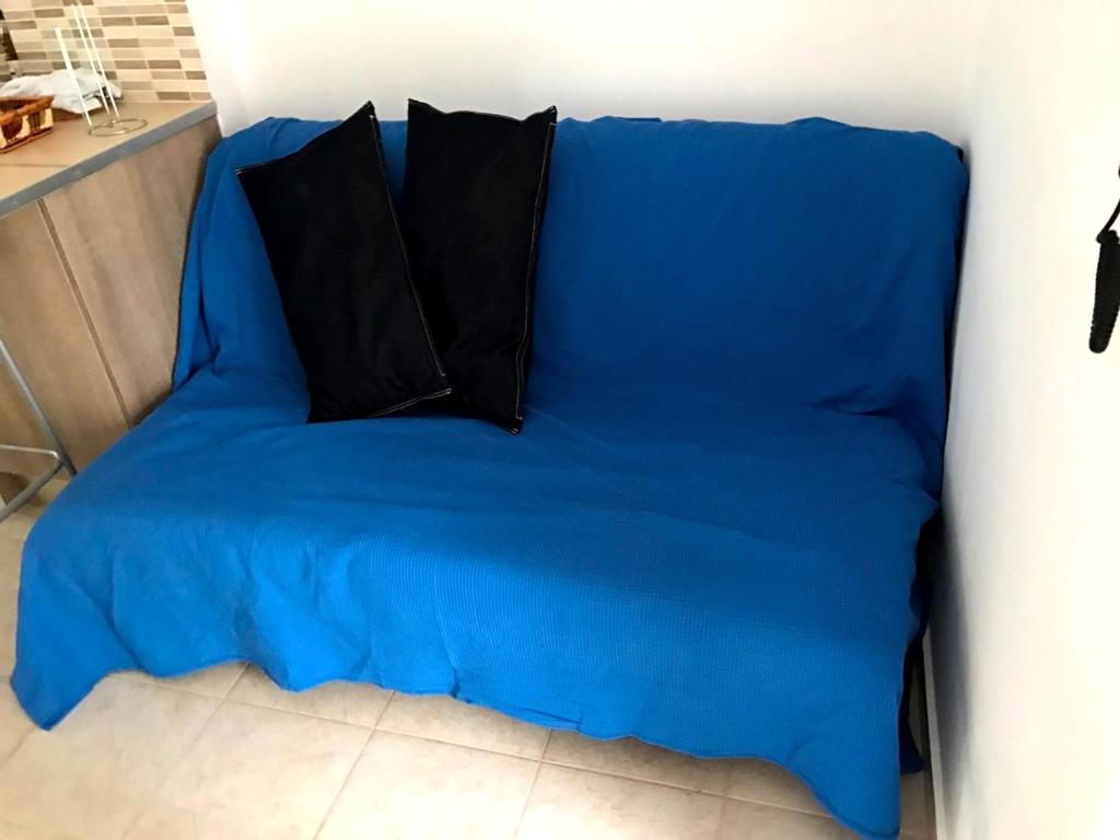 ルートラキにあるLoutraki Studioの青いソファ(黒い枕2つ付)