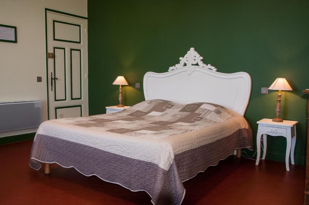 a bedroom with a white bed with green walls at Mas la Cigaliere in Venasque