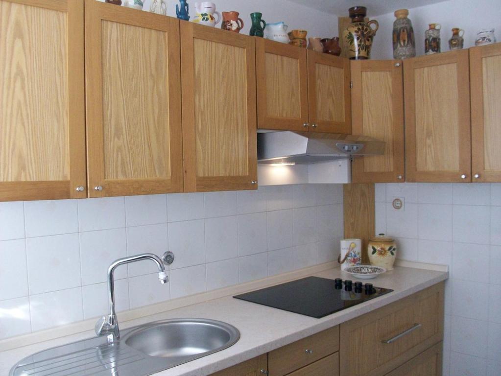 kuchnia z drewnianymi szafkami i zlewem w obiekcie Apartments Lada 1217 w mieście Premantura