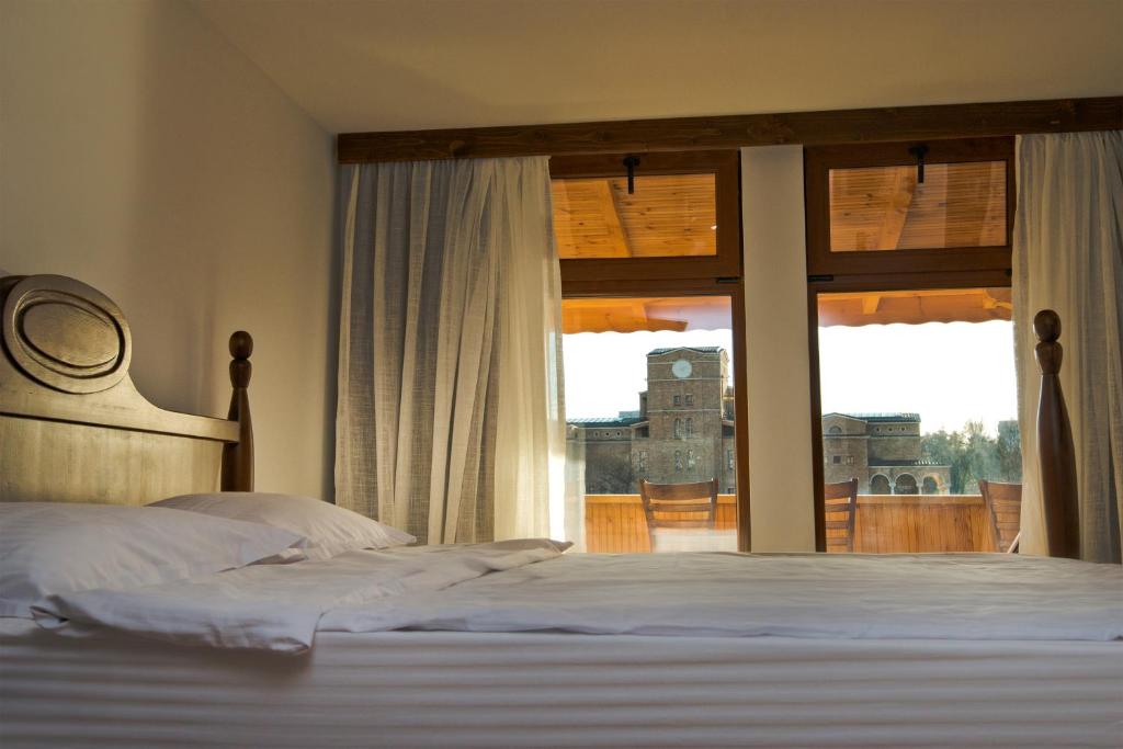 a bedroom with a bed and a large window at The Lion's Residence in Veliko Tŭrnovo