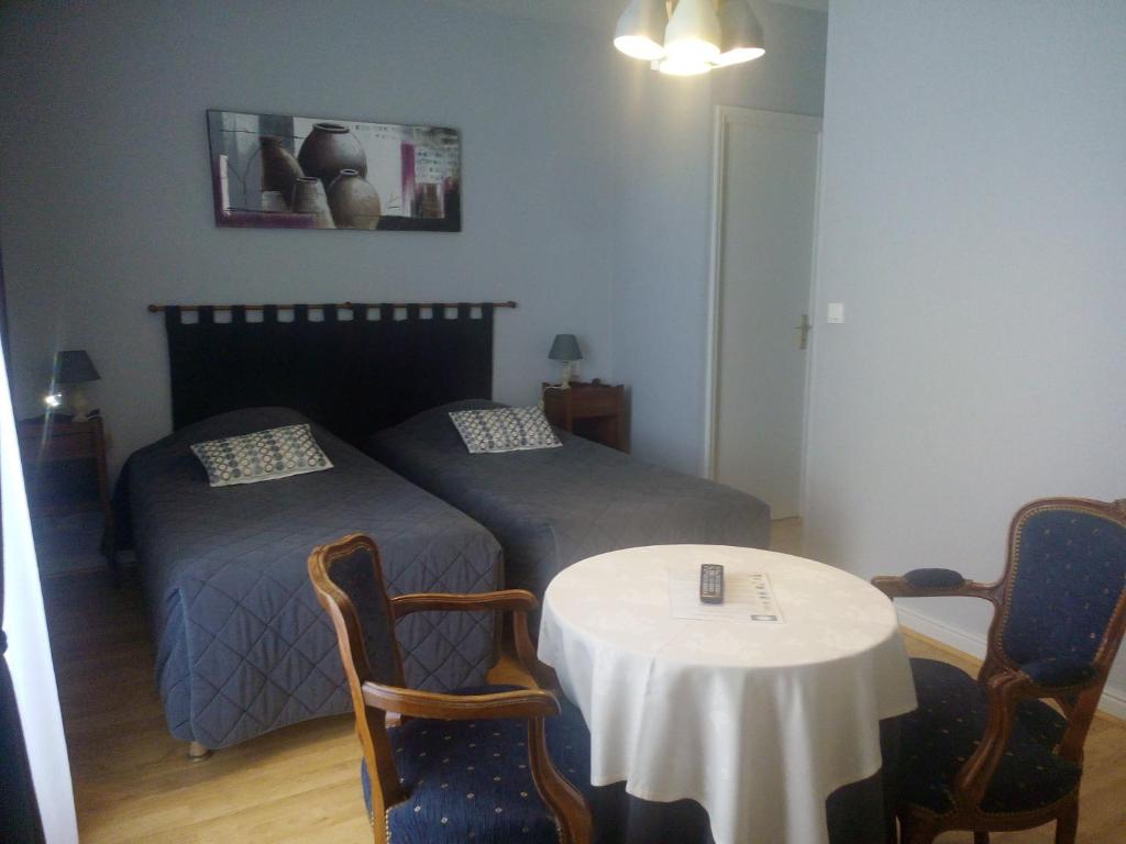 謝爾河畔努瓦耶的住宿－樂克洛斯切爾酒店，一间卧室配有两张床和一张桌子及椅子