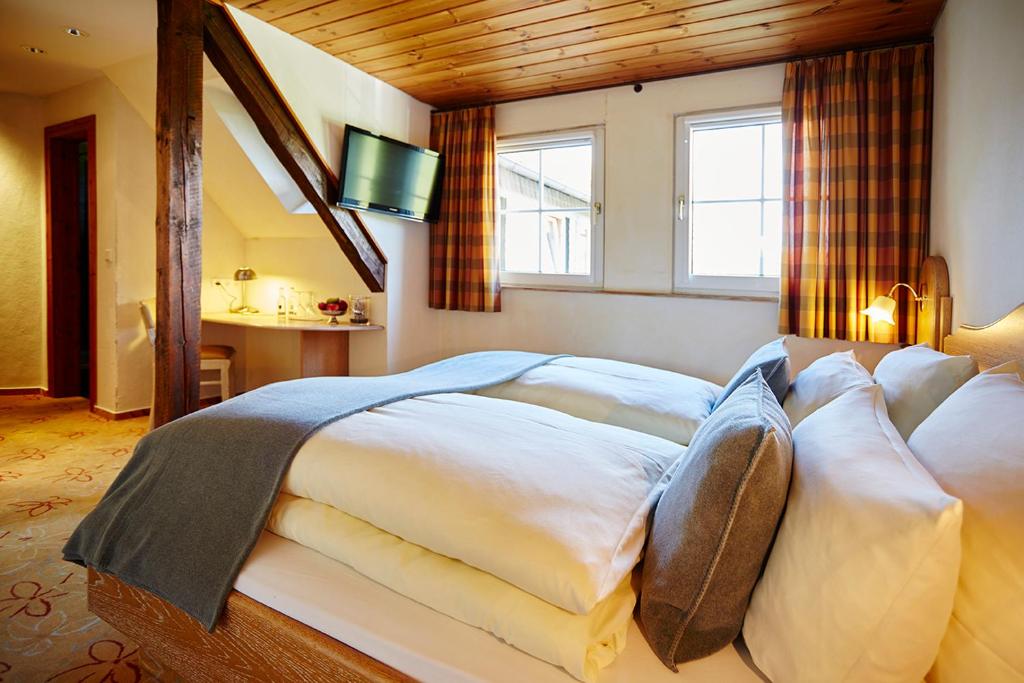 a bedroom with a large bed with a window at Steinbergs Wildewiese NaturHotel in Wildewiese