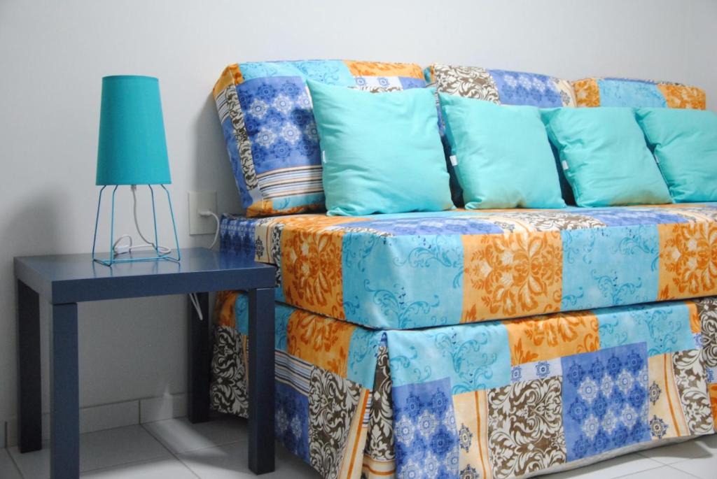 a couch sitting next to a table with a lamp at Etiqueta Hotel in Santa Cruz do Capibaribe