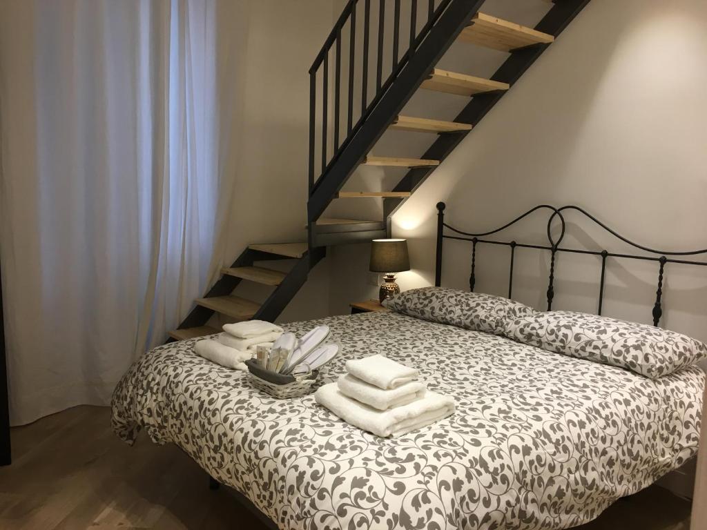 una camera da letto con un letto con asciugamani e una scala di La Scalinata di Chiaia a Napoli