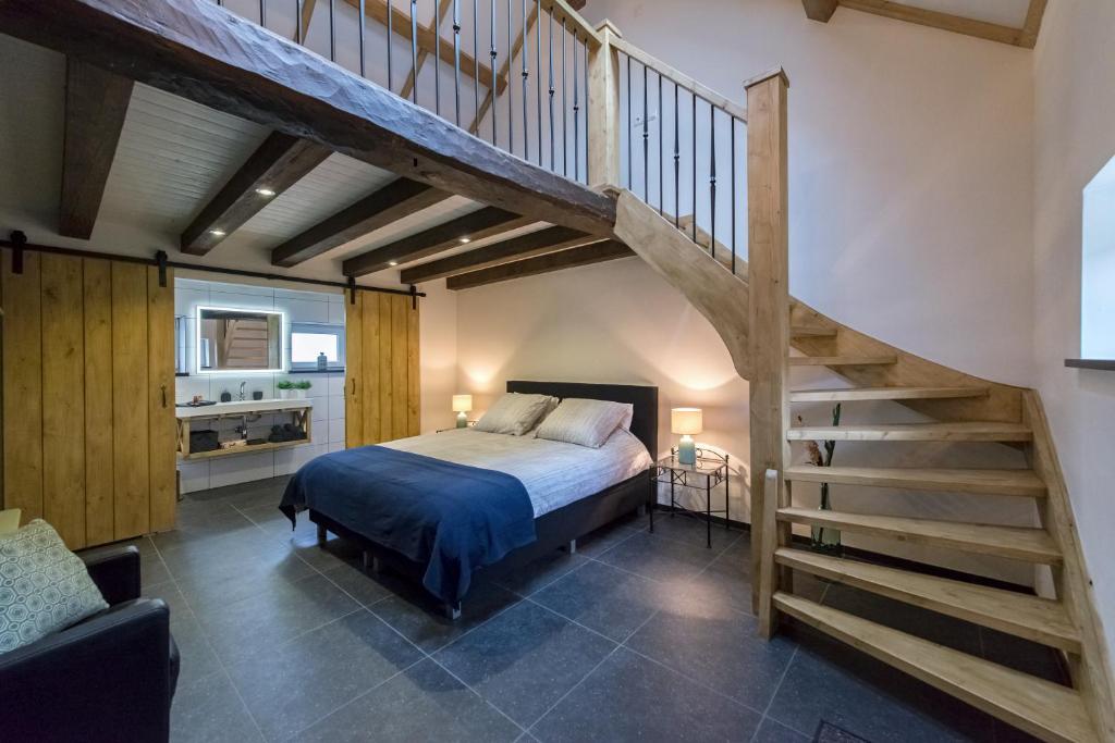 ein Schlafzimmer mit einem Bett und einer Treppe in der Unterkunft Op Geneijgen in Grathem