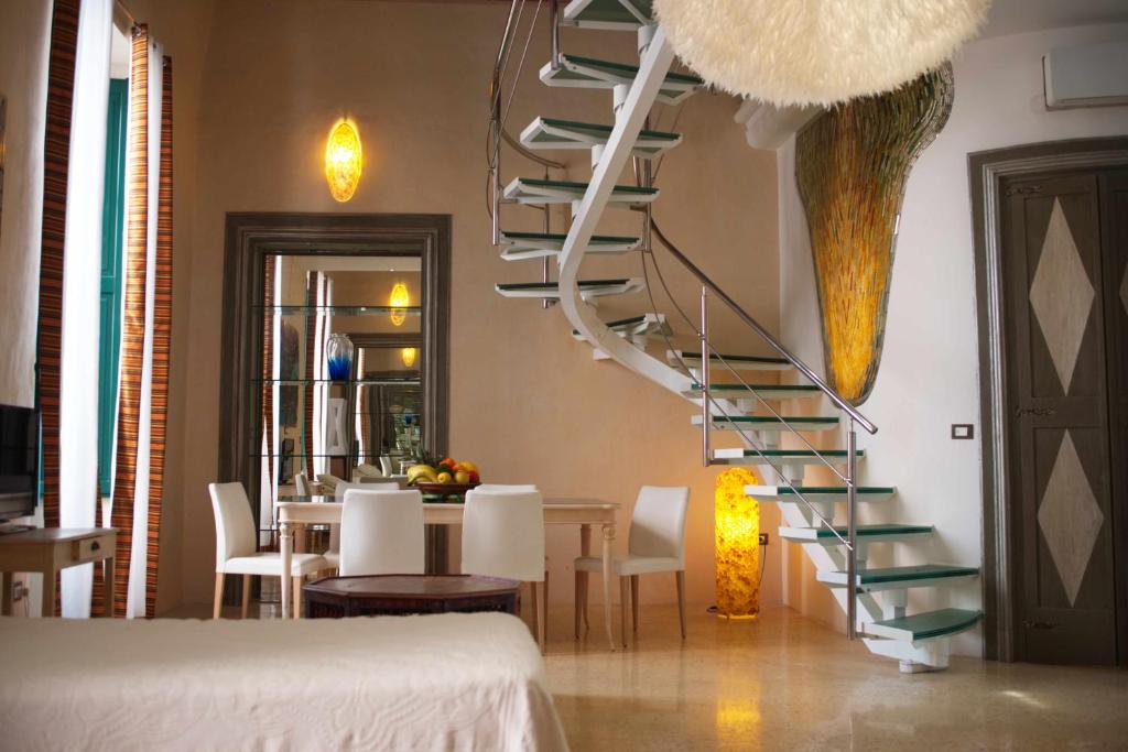 a spiral staircase in a dining room with a table at Palazzo Salapolis - Luxury Apartments in Gallipoli