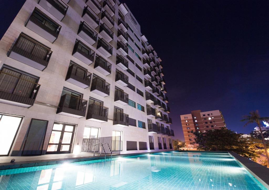 una piscina frente a un edificio por la noche en Kadda Hotel en Hualien