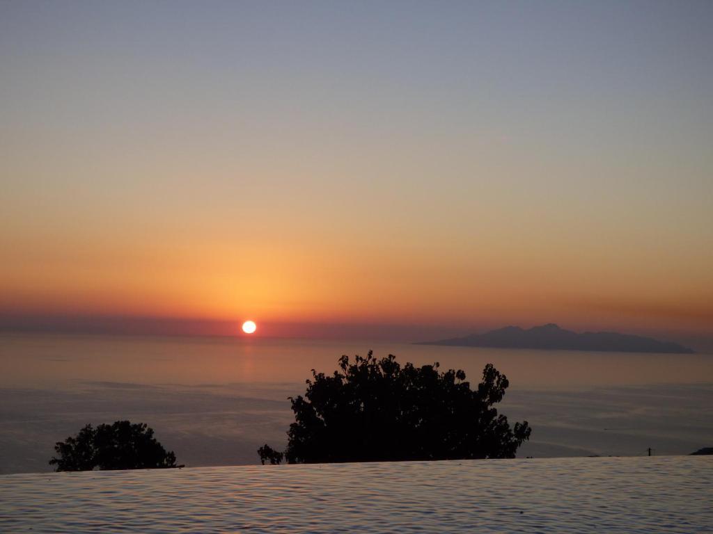 a sunset from the top of a mountain at Rampelia Apartments in Imerovigli