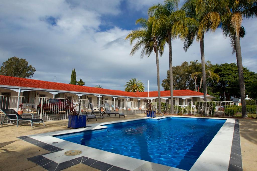 a swimming pool with a pool table and chairs at Tuncurry Beach Motel in Tuncurry