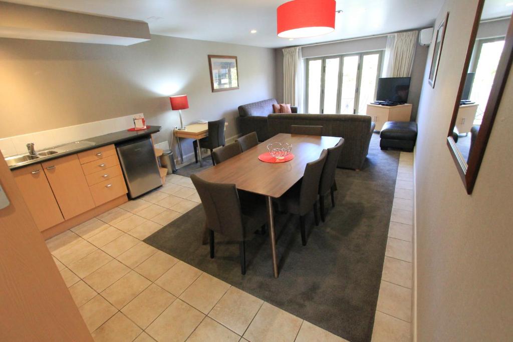 a kitchen and a living room with a dining room table at Voyager Apartments Taupo in Taupo