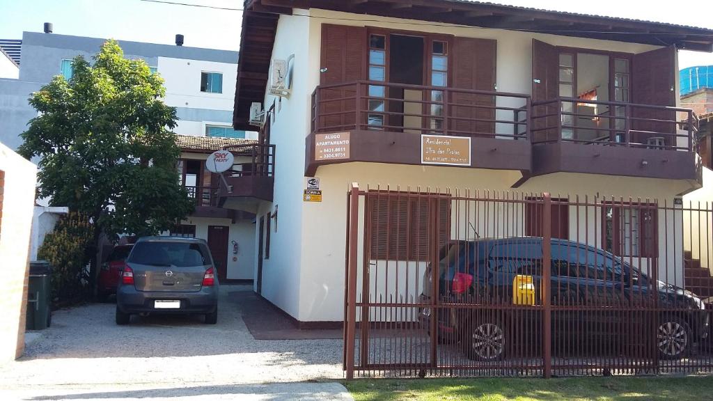 dos autos estacionados frente a una casa en Residencial Ilha das Praias, en Florianópolis