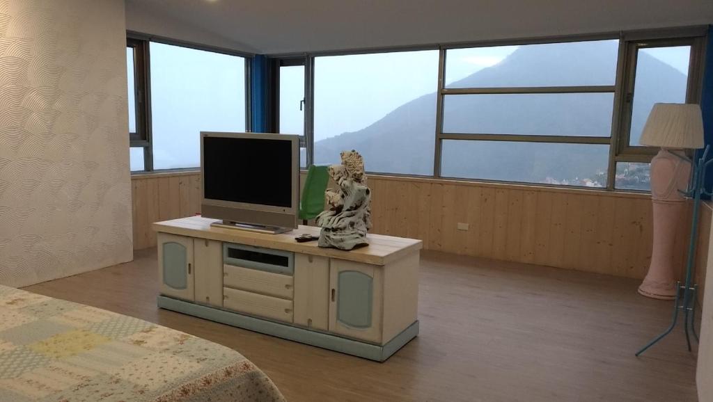 una stanza con una televisione su un mobile con una statua di gatto di Good Time B&B a Jiufen