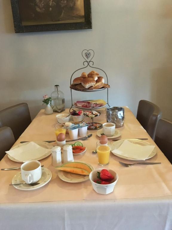 una mesa cubierta con platos y tazones de comida en Hotel Het Anker, en Heythuysen