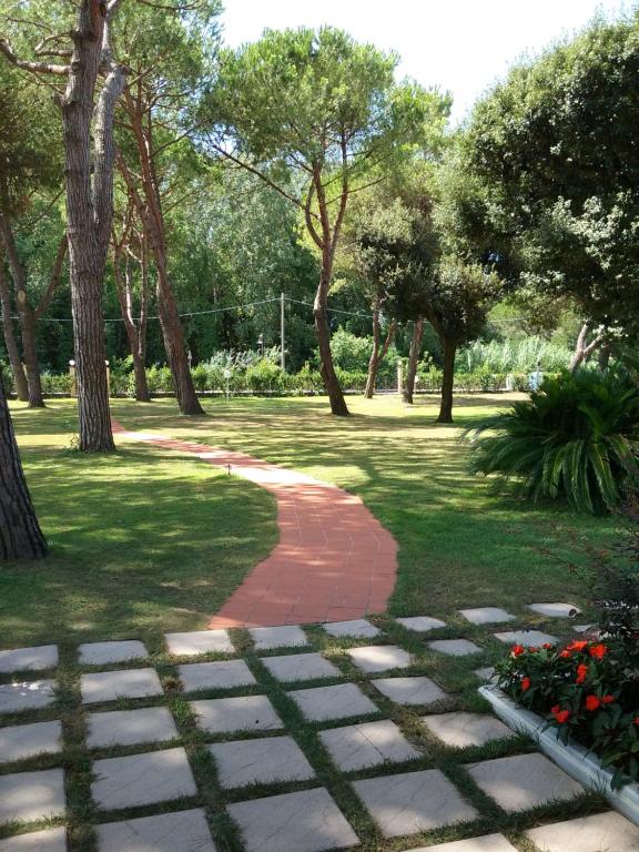 un camino en un parque con árboles y césped en Hotel Alcione, en Marina di Massa