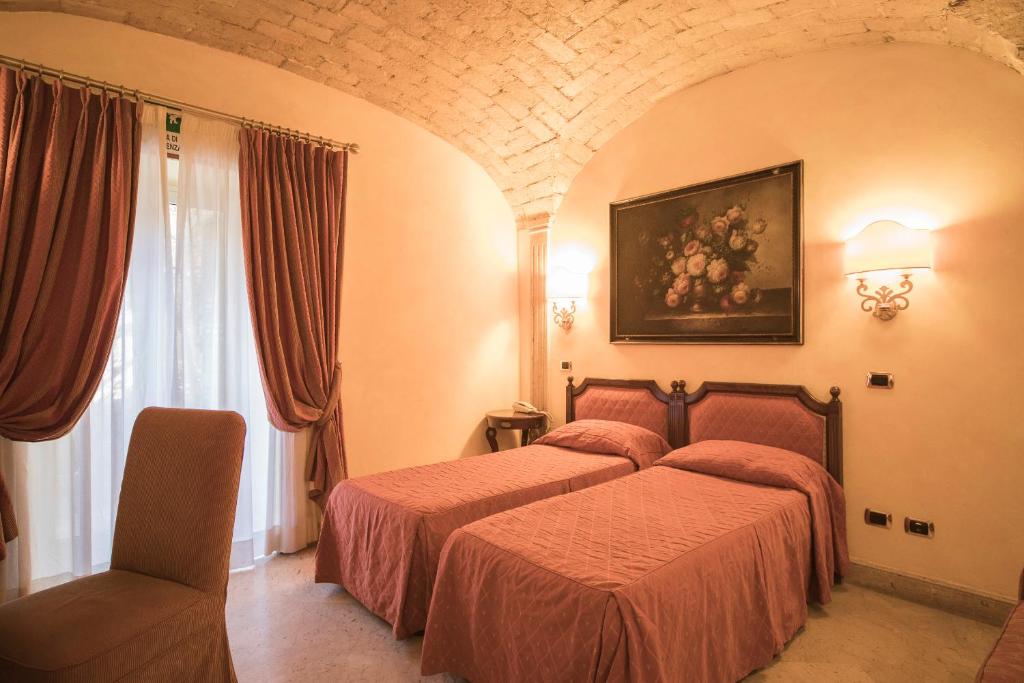 Postel nebo postele na pokoji v ubytování Hotel Donatello