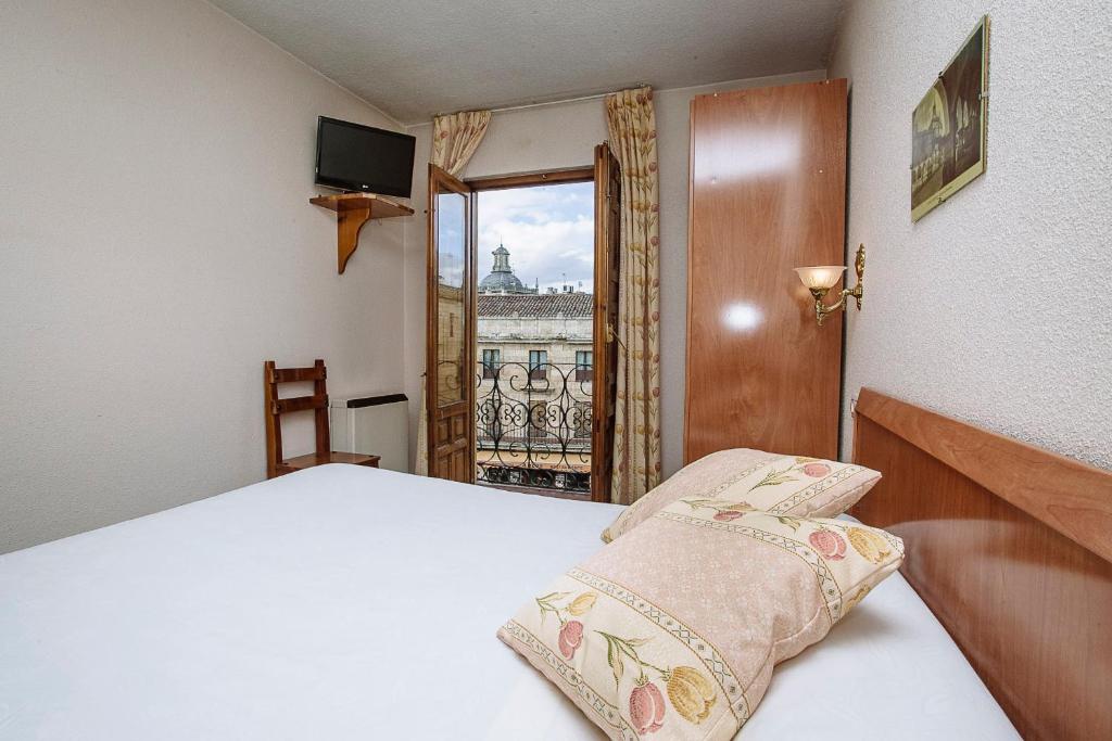 1 dormitorio con cama y vistas a la ciudad en Hostal Plaza, en Ciudad Rodrigo
