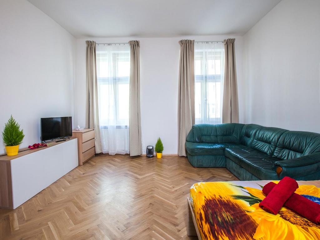 a living room with a green couch and a television at Beautiful Central Apartment Thámova in Prague