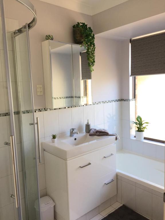 a bathroom with a sink and a shower and a mirror at Murdoch Station in Perth