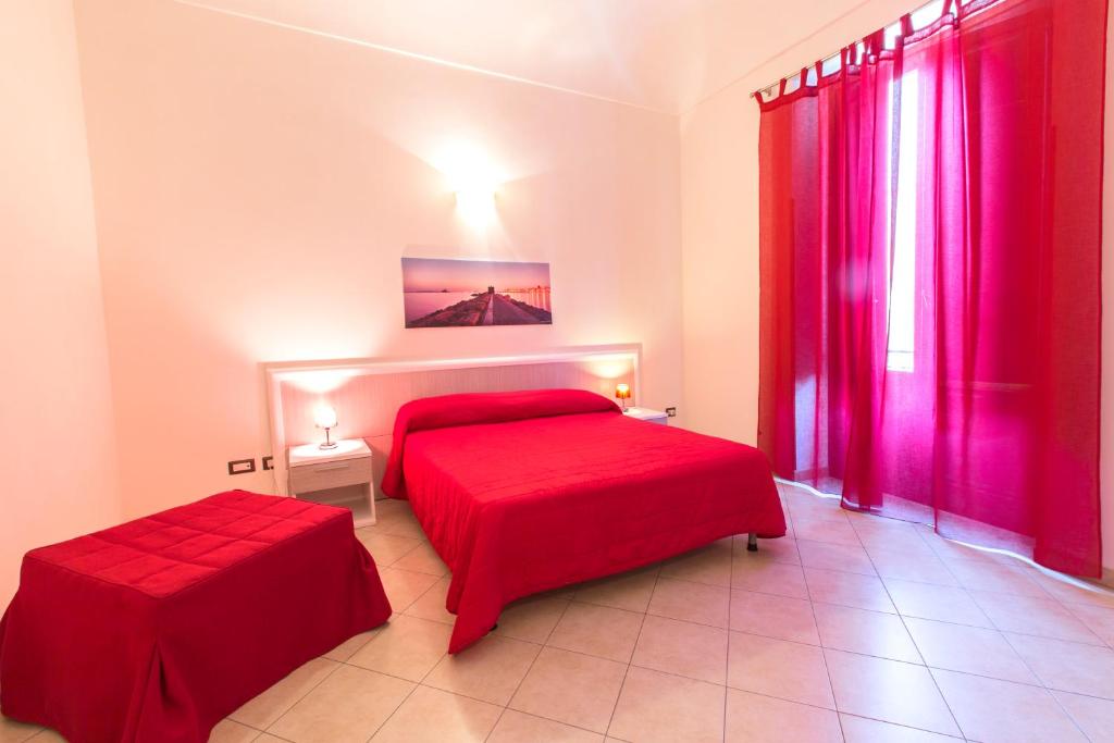 a red bedroom with two beds and a window at Residence Barbara in Trapani