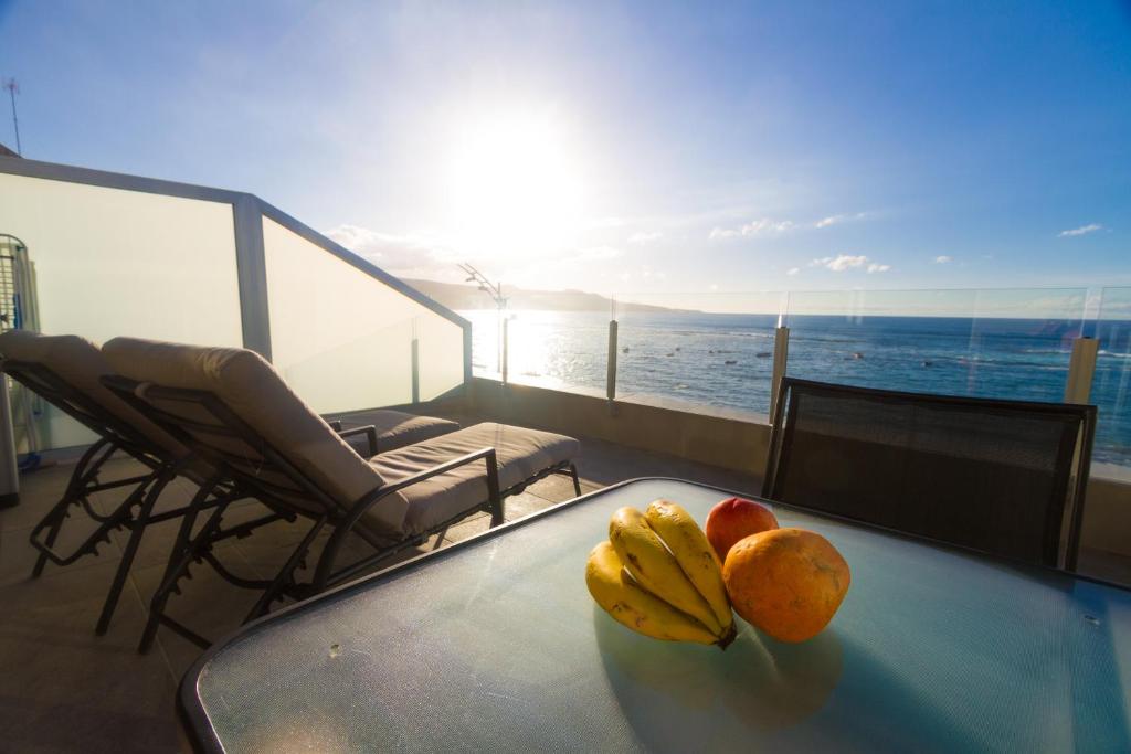 ラスパルマス・デ・グランカナリアにあるLiving Las Canteras Homes - FRONT-LINE BEACHのバルコニーの上に果物を用意したテーブル