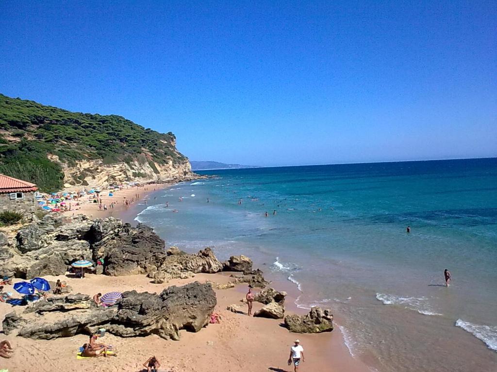 a group of people on a beach near the ocean at Casas El Suspiro in Zahora