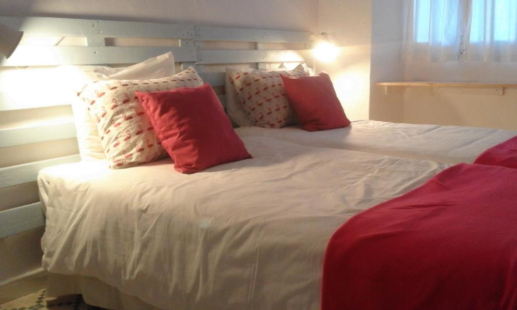 ベヘール・デ・ラ・フロンテーラにあるApartamentos Patio de la Juderiaのベッド(赤と白の枕付)