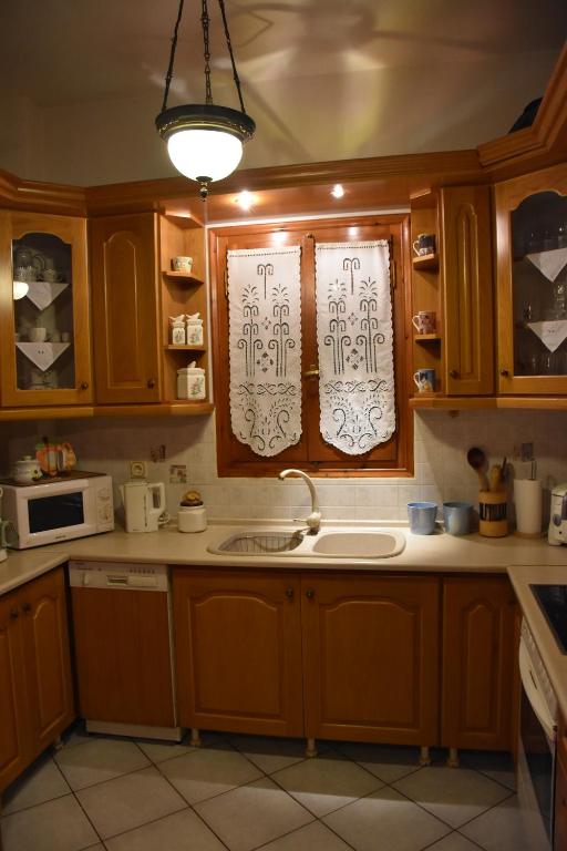 uma cozinha com armários de madeira, um lavatório e uma janela em Anna's Villa Portaria em Portariá