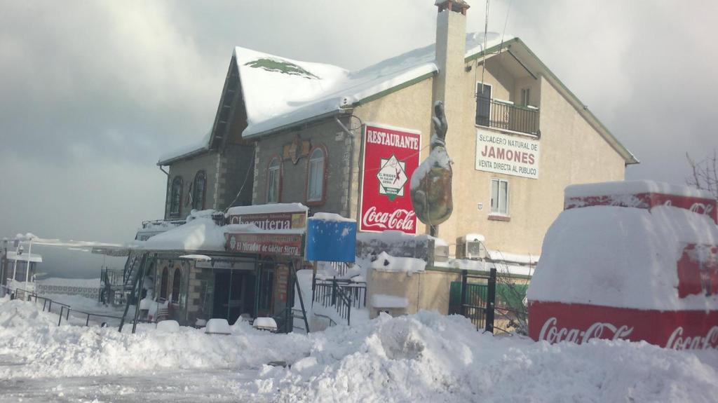 a building covered in snow in front at La alacena de Jose y Rosi in Güéjar-Sierra