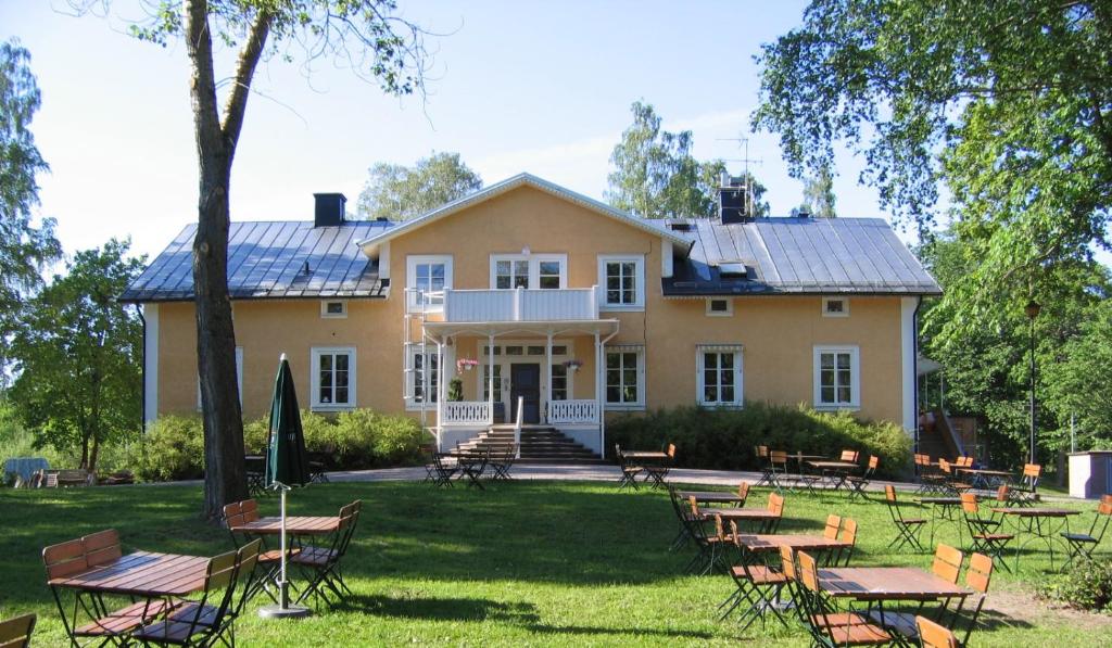 a house with tables and chairs in front of it at Långshyttans Brukshotell in Långshyttan