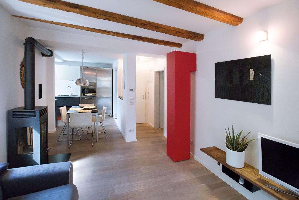 sala de estar con chimenea y pared de acento rojo en Ulivo Suites - apartments, en Bolzano