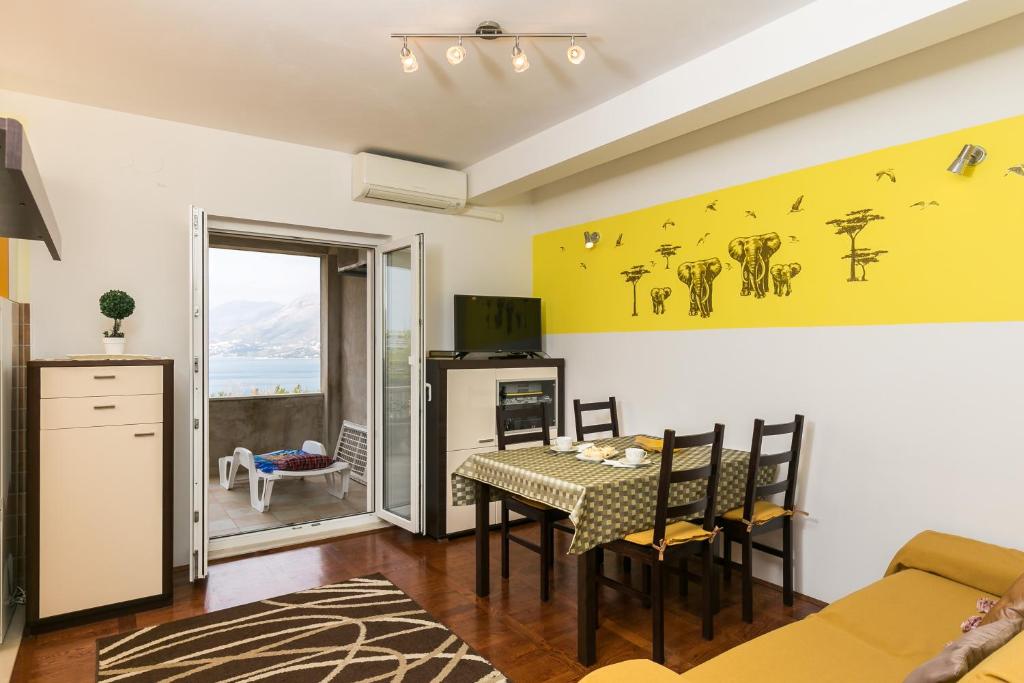 uma cozinha e sala de jantar com mesa e cadeiras em Apartments Oliva em Cavtat