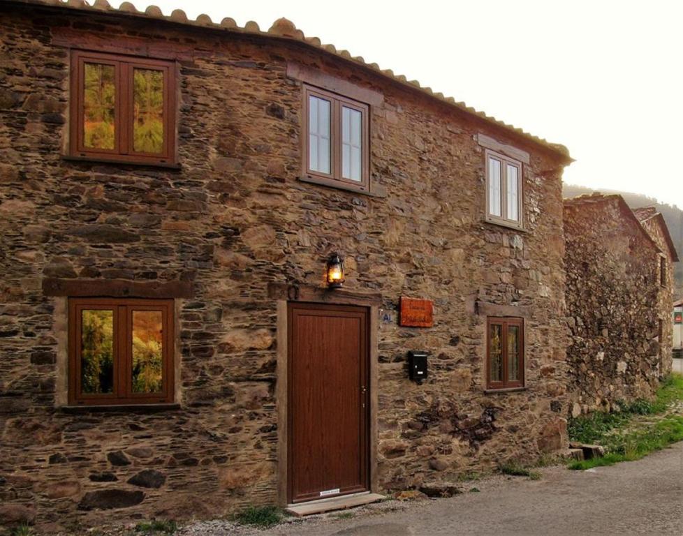 un antiguo edificio de piedra con puerta y ventanas en Casa da Eduardinha, en Góis