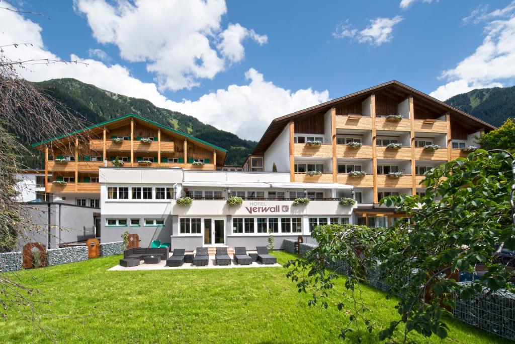 a hotel in the mountains with a green lawn at Romantik Hotel Verwall in Gaschurn
