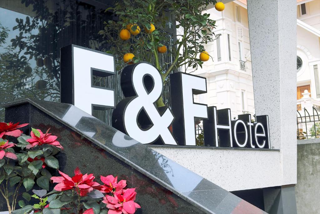 a sign on the side of a building with flowers at F & F Hotel in Hai Phong