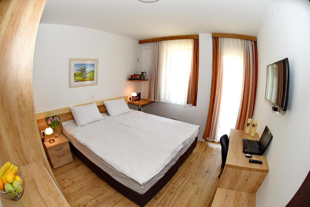 a bedroom with a bed and a desk with a laptop at Boutique Villa Arte in Ohrid