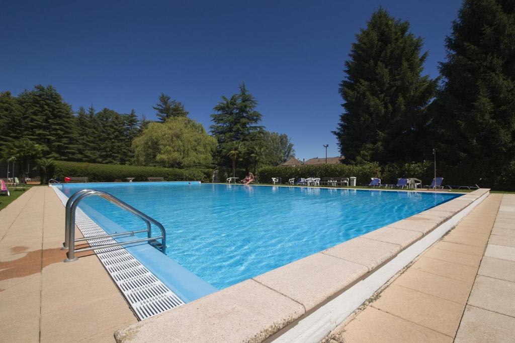 a large blue swimming pool with a metal hand rail at Riva del Caolino in Ispra