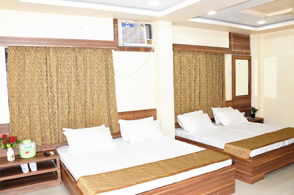 um quarto com 2 camas e uma janela em HOTEL ATA INN AND RESTAURANT (20 Mtrs from Dargah), Ajmer em Ajmer