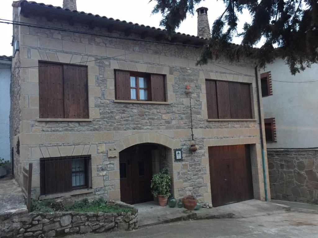 stary kamienny dom z drewnianymi drzwiami i oknami w obiekcie Casa rural Bal D'Onsella w mieście Lobera de Onsella