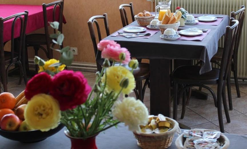 a table with bowls of food and flowers on it at Hôtel Evian Express - Terminus in Évian-les-Bains