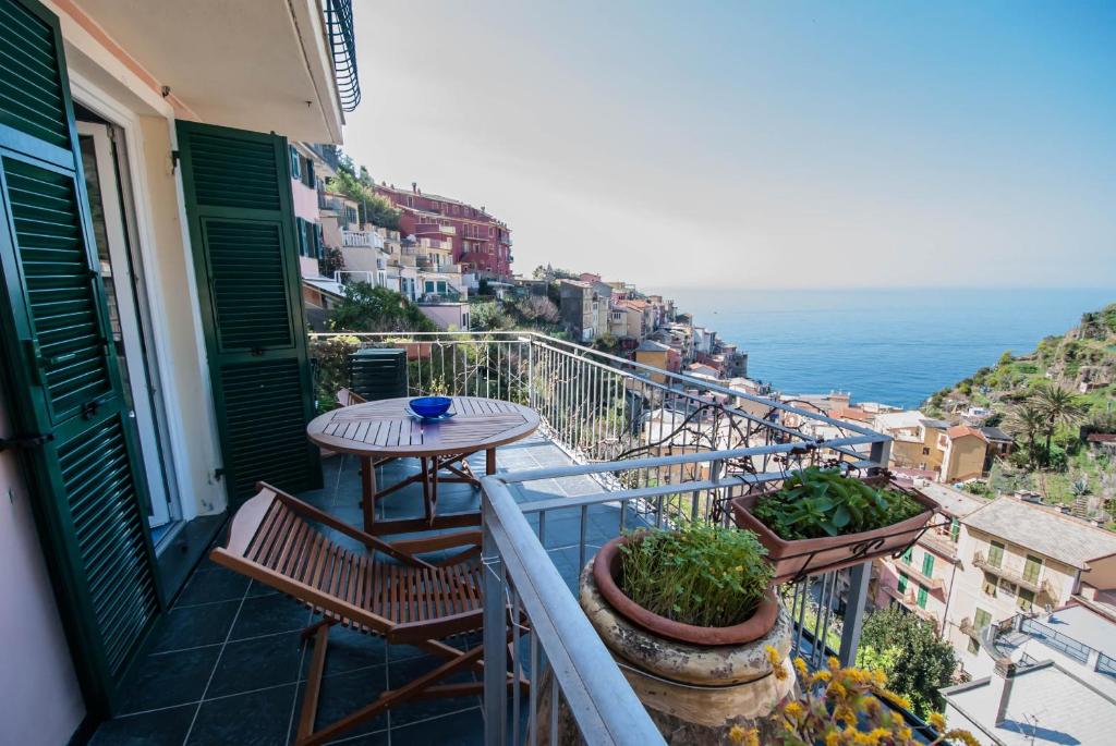 a balcony with a table and chairs and the ocean at Luxury Seaview Apartments Manarola by Arbaspàa in Manarola