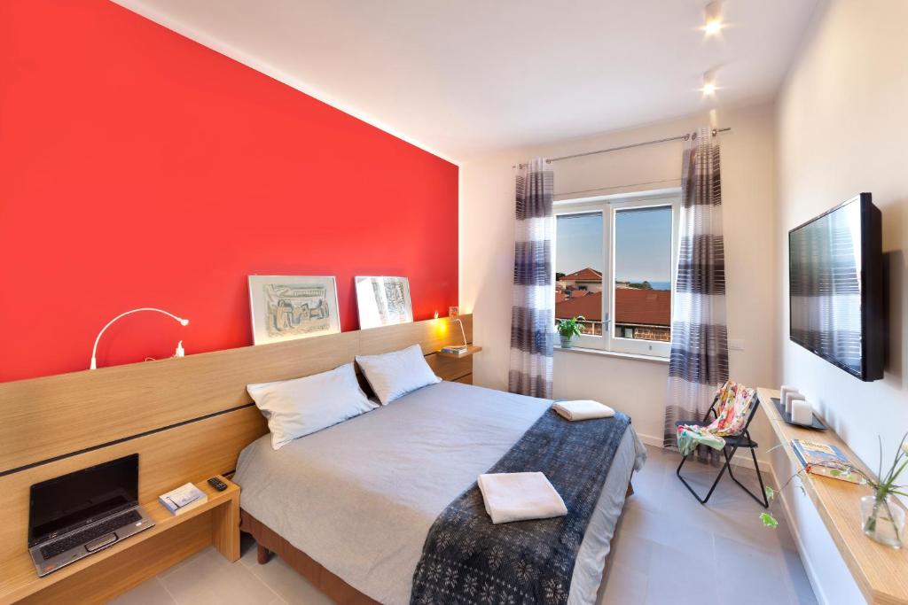 ソレントにあるOrsola Sorrento sea & sunの赤い壁のベッドルーム1室(ベッド1台付)