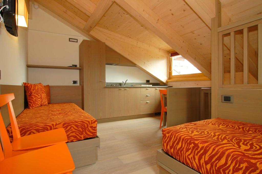 a bedroom with two beds in a loft at Dolomiti Lodge Villa Gaia in Valle di Cadore