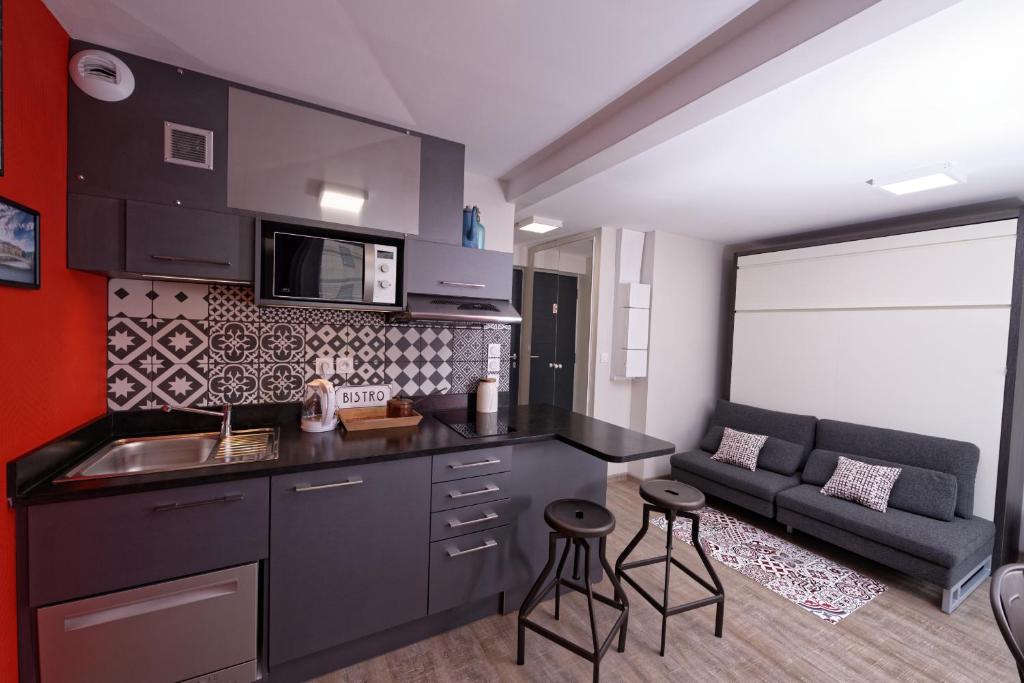 une cuisine avec un évier et un canapé dans une chambre dans l'établissement At home in lyon, à Lyon
