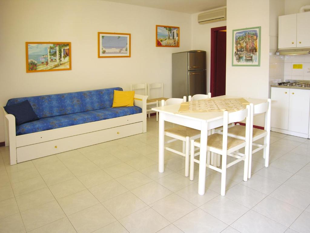 a living room with a blue couch and a table at Appartamenti Alaska in Bibione