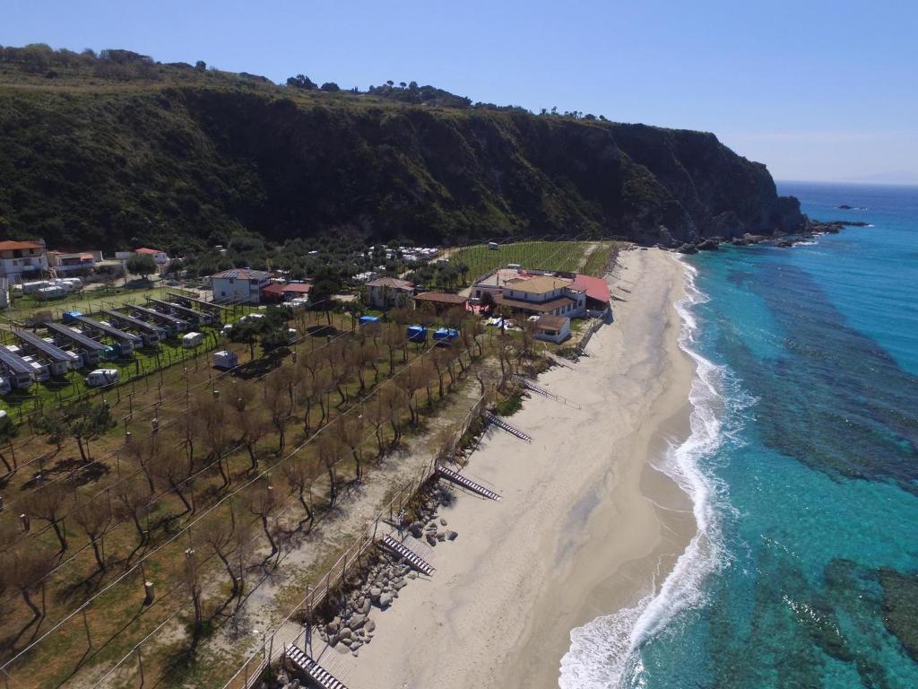 una vista aerea su una spiaggia con un resort di Villaggio Camping La Scogliera a Ricadi